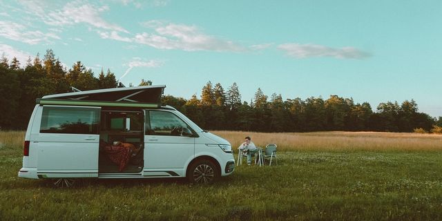 Bulli auf einem Feld mit aufgestelltem Dach